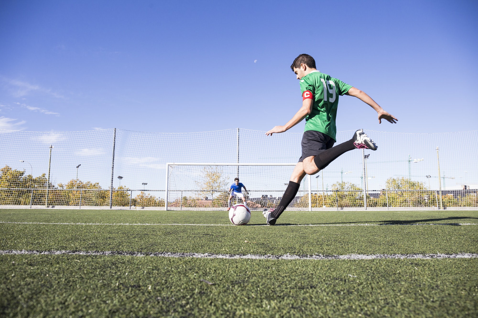 Football player shooting the ball on football field